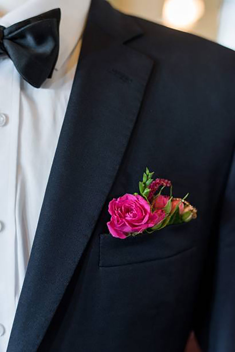 Bright flower boutonniere tucked into jacket pocket.