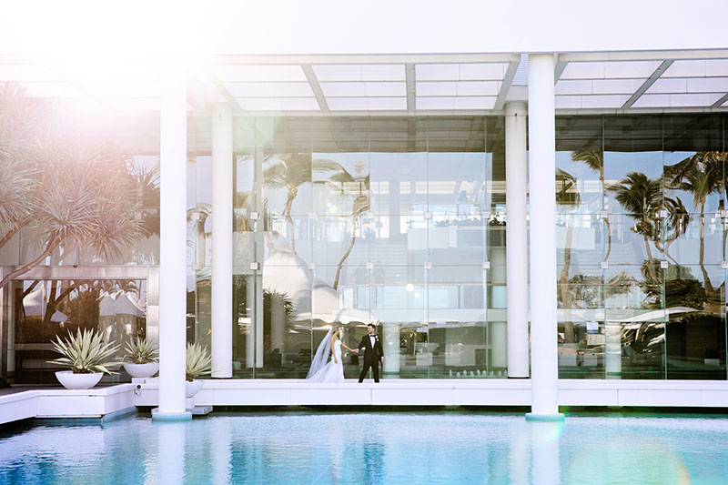 Bride and Groom walking by the pool at Sheraton Grand Mirage Resort, Gold Coast.