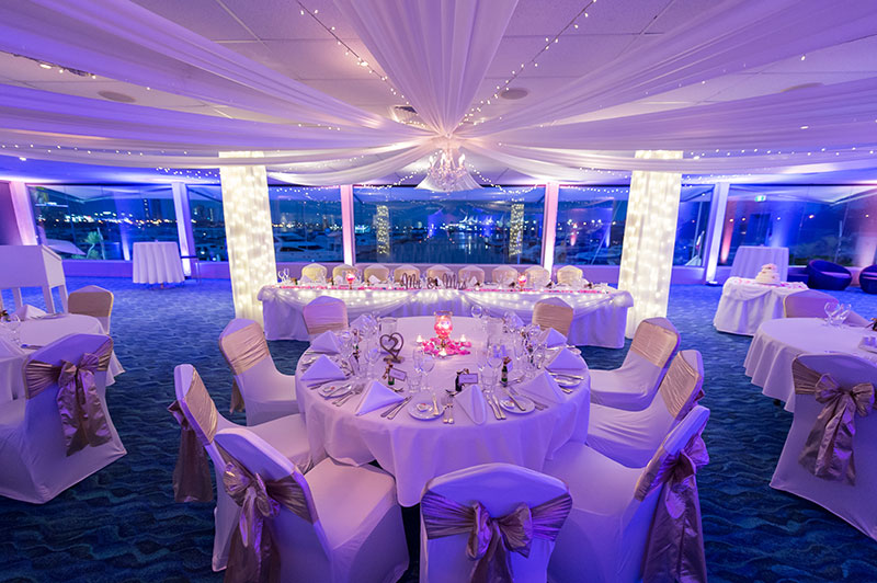 Southport Yacht Club set up for a wedding reception with purple lighting.