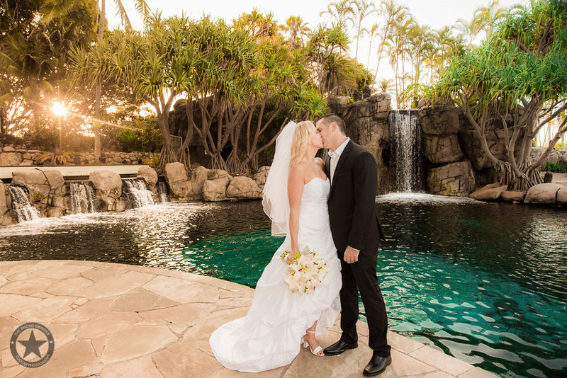 Bride and Groom kissing in front of the pool at Surfers Paradise Marriott Resort & Spa.