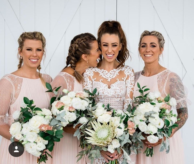 Bride and bridesmaids with classic and native flower wedding bouquets.