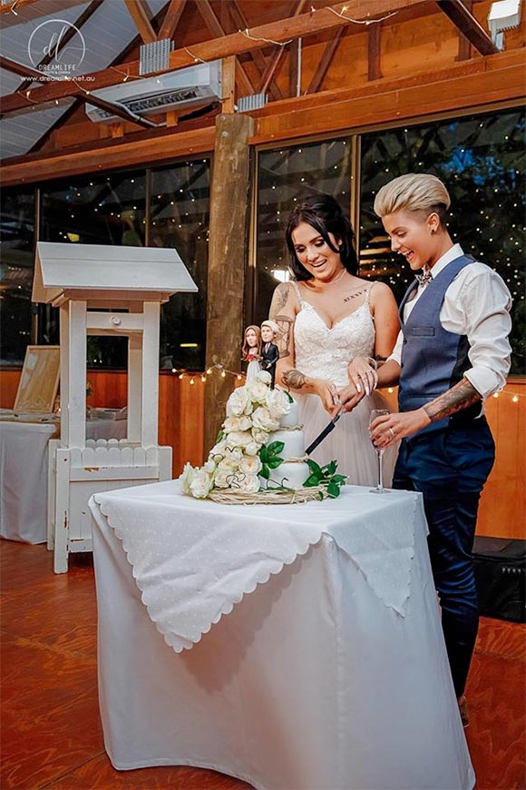 Lesbian couple cutting the bridal cake