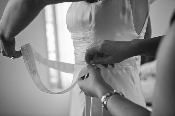 Black and white closeup tieing wedding dress