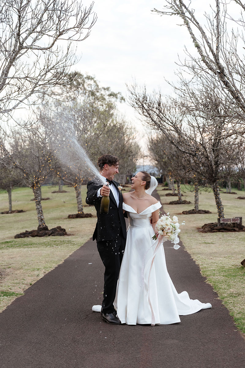 Chelea & Christian tie the knot at Preston Peak Winery Function Centre and are shown popping a celebratory bottle of sparkling.