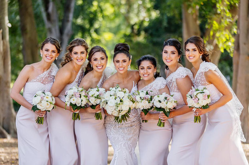 Bride and bridesmaids holding white bouquets from Brisbane Market Flowers.