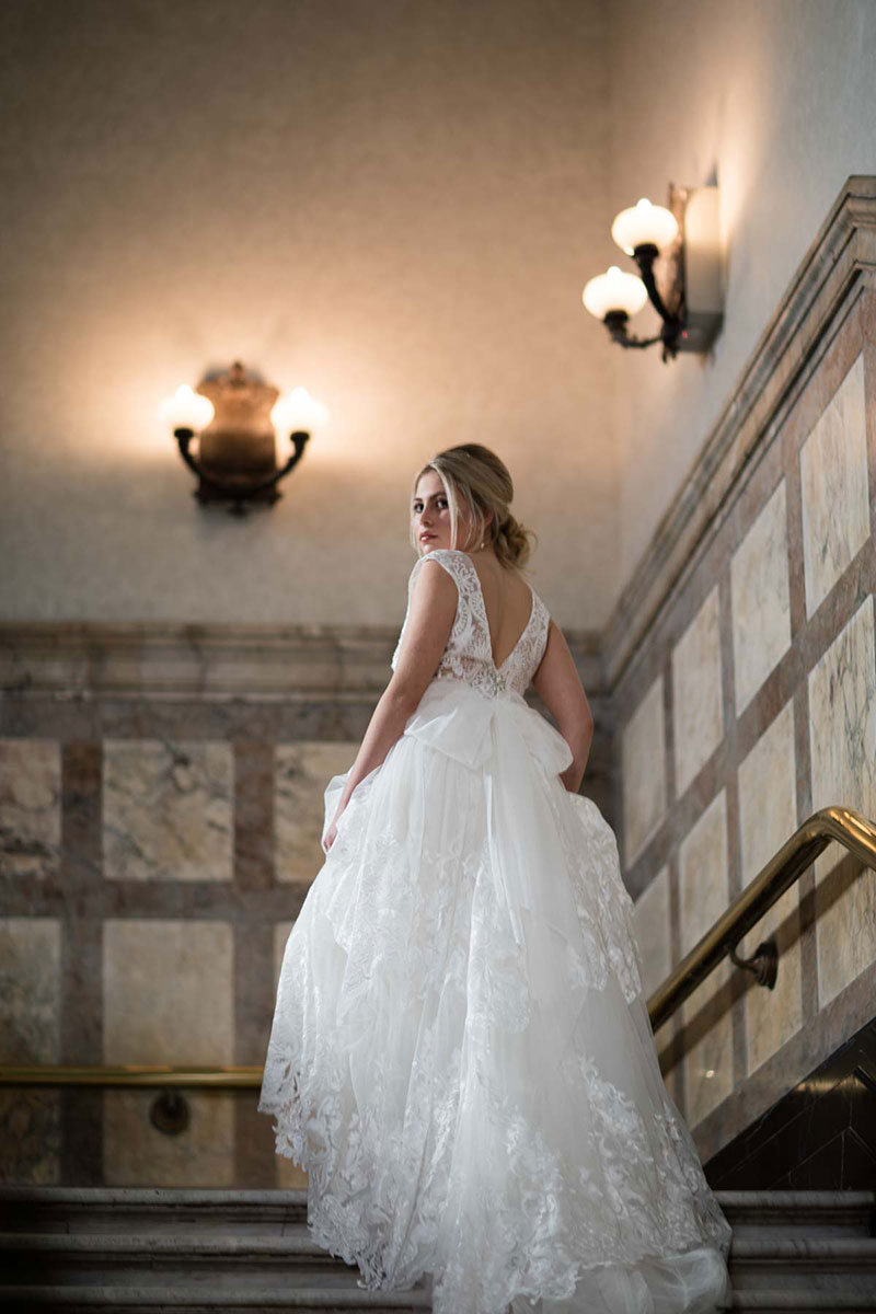 Bride walking up stairs in a traditional wedding gown by Fiorenza.