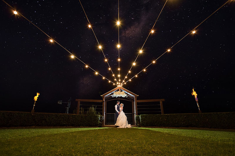 Bride and groom at night with lights at Flaxton Gardens.