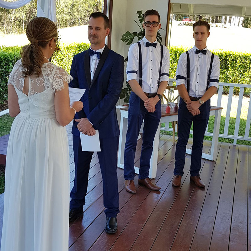 Bride and Groom getting married with two young groomsmen looking on