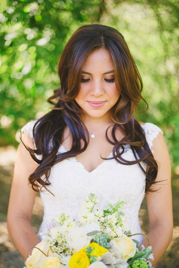 Bride holding bridal bouquet of yellow and white flowers
