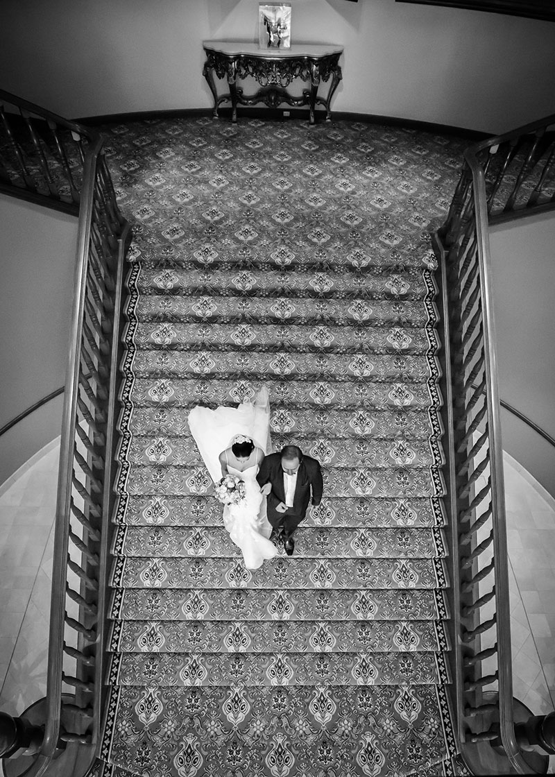 Bride and Groom walking down a lavish looking staircase.