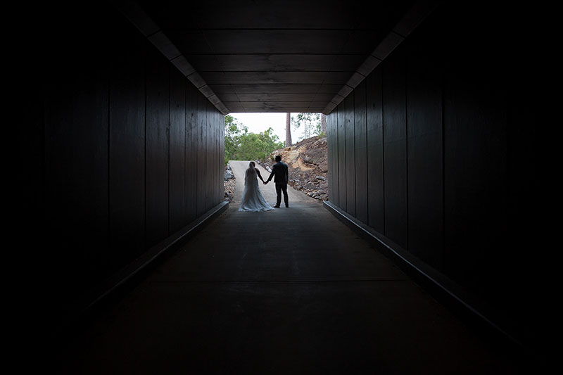 Bride and Groom walking through a tunnel.