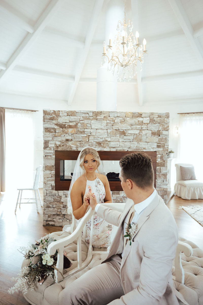 Photo by DK and Co. Photography of couple sitting under a chandelier.