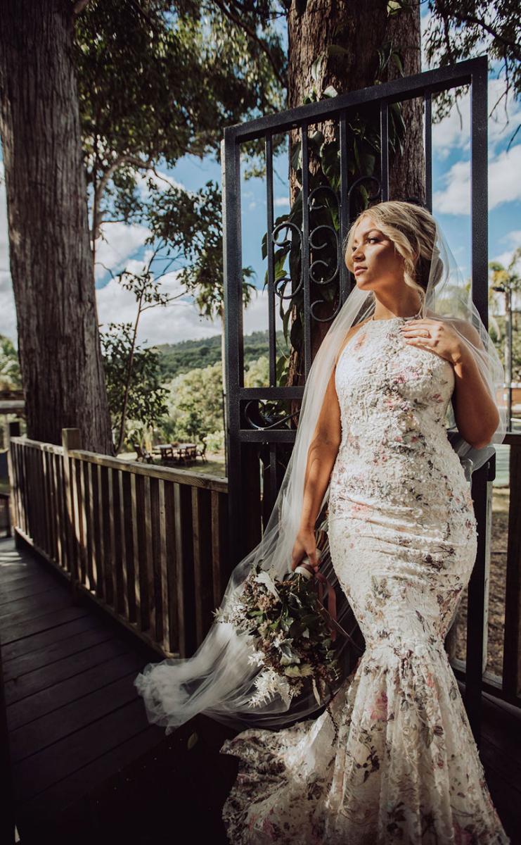 Photo by DK and Co. Photography of model in wedding gown holding wildflower bouquet.