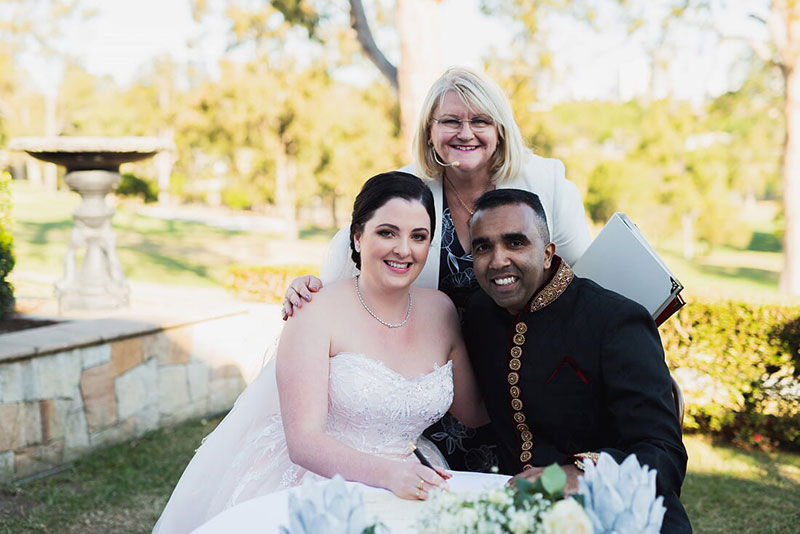 Annette Richards Celebrant posing with Bride and Groom as they sign their Marriage Certificiate.