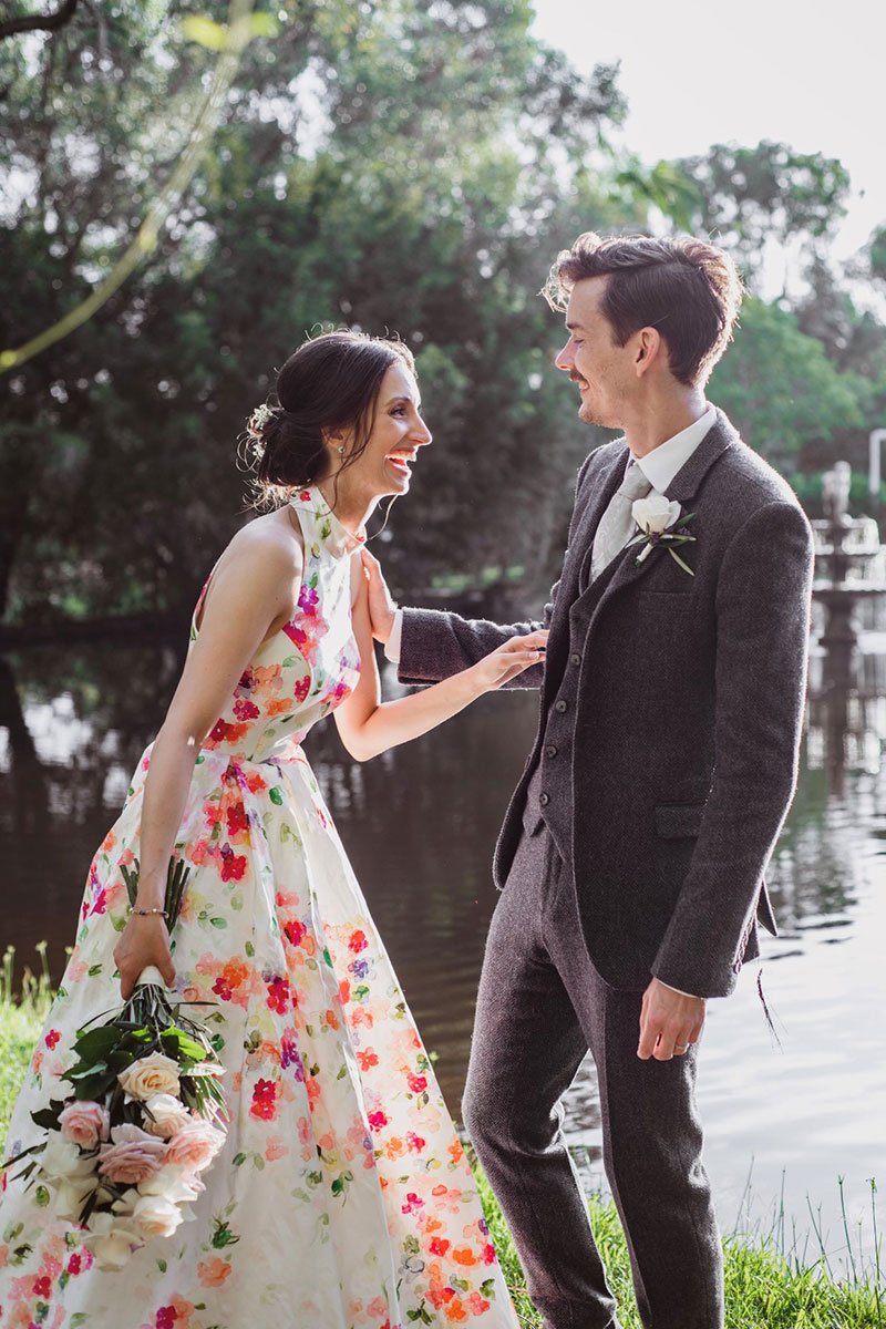 Bride in colourful wedding gown laughing with her Groom.