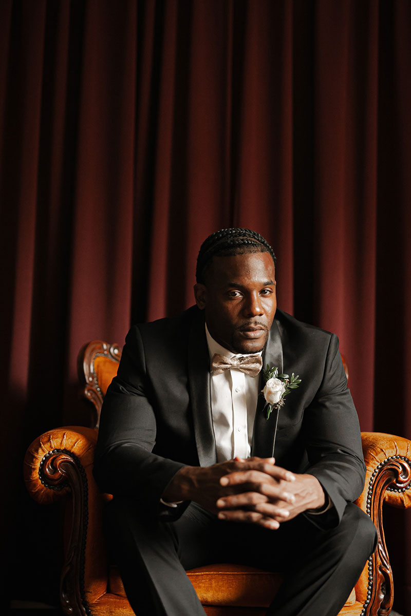 Photo by Tom Judson Photography of Groom sitting in chair with clasped hands..