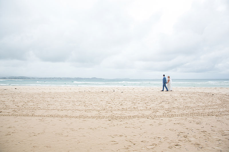 Couple walking together on beach.