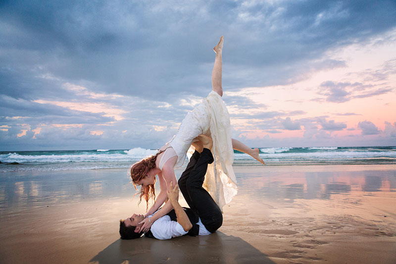 Couple in a dance pose on the beach.
