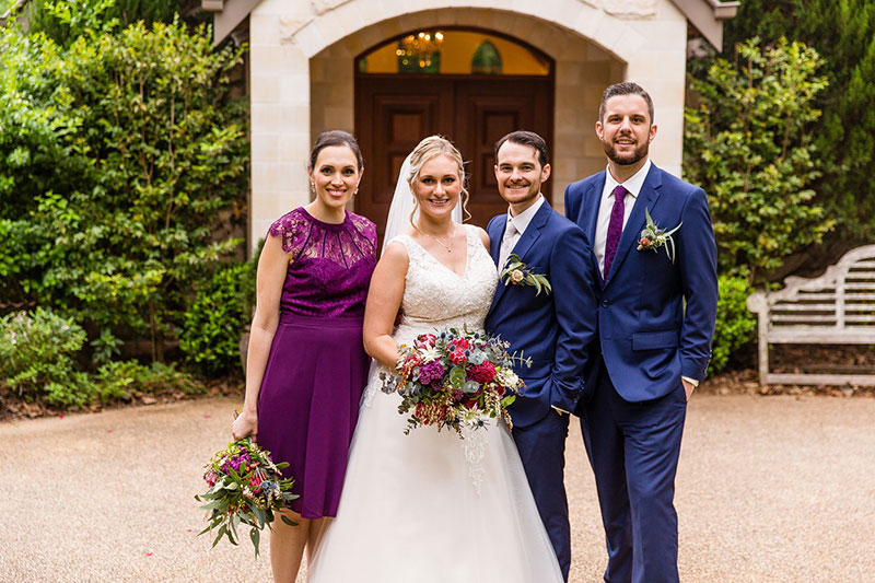 Bride and Groom smiling with their Bridesmaid and Groomsman.