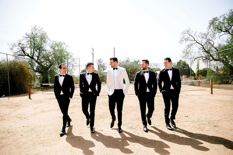 Groom in White Jacket with his Groomsmen in Black.