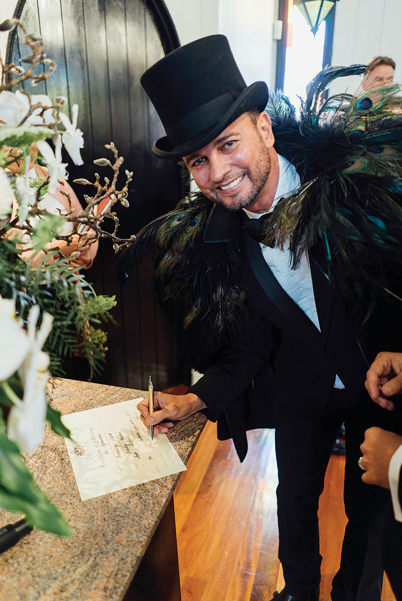 Brad and Scott happily signing their marriage certificate.