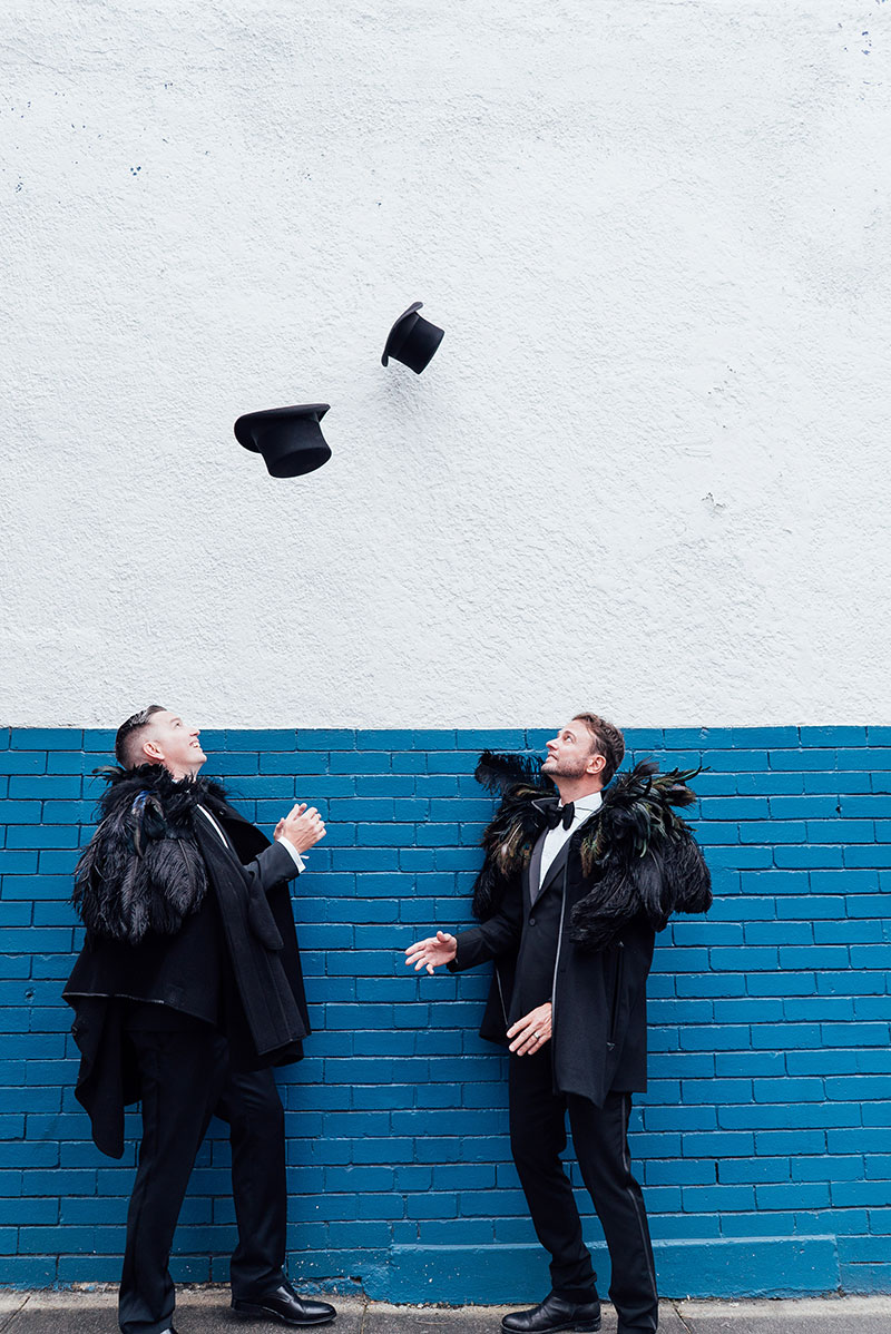 Brad and Scott throwing their hats in the air after getting married.