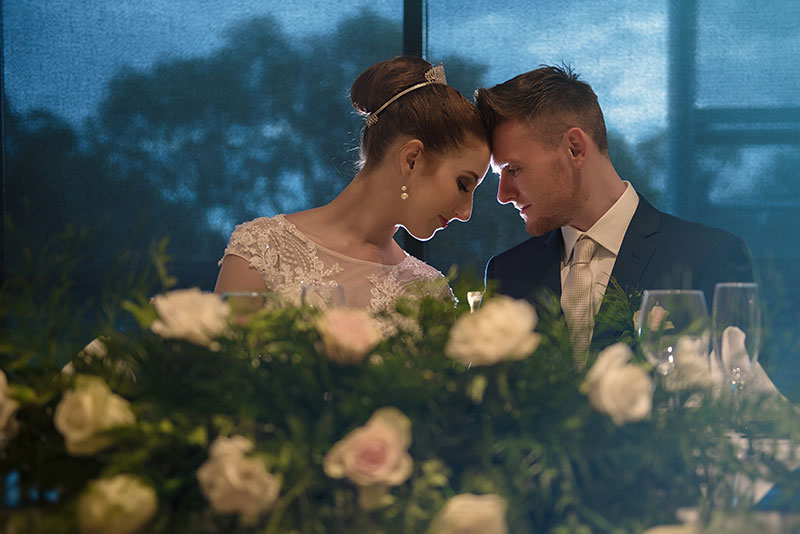 Bride and Groom with their heads together at wedding reception.