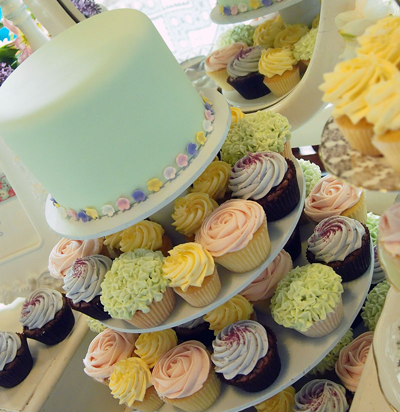 Vintage wedding cake with cupcake tiers.