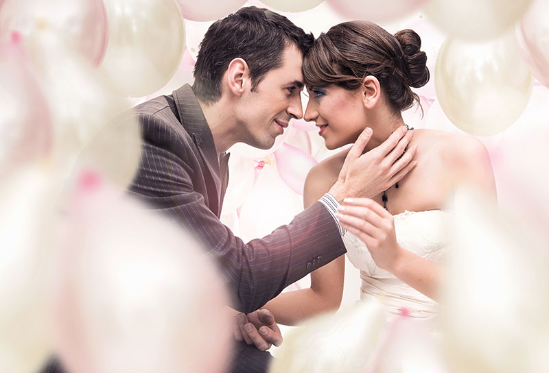 Bride and Groom together amongst balloons.