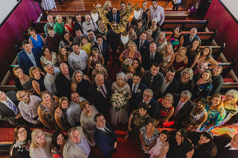 Married couple pose with their guests at Broadway Chapel.