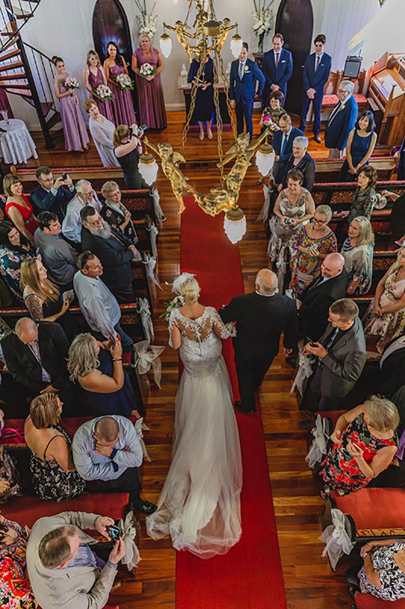 Bride walking up the aisle to meet her husband-to-be at Broadway Chapel.