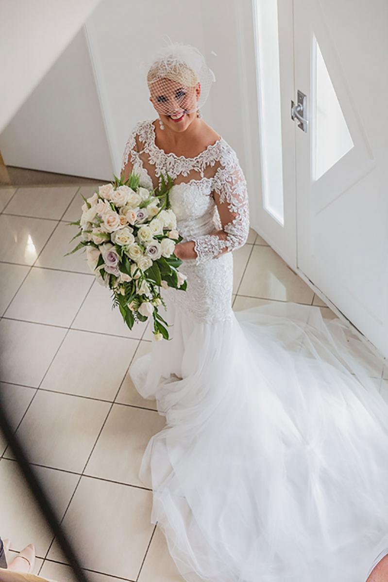 Bride holding flowers in her gorgeous wedding gown.