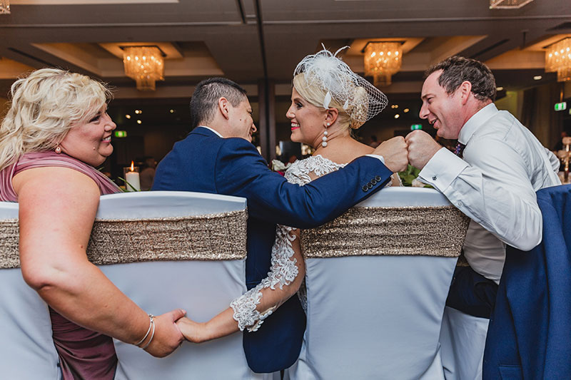 Happy bride and groom with wedding party at their reception.