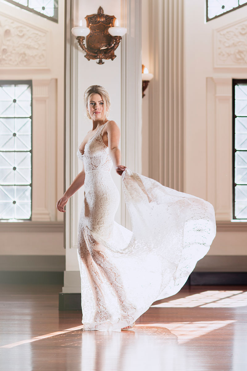 Bride holding the hem of her lace Fiorenza gown.