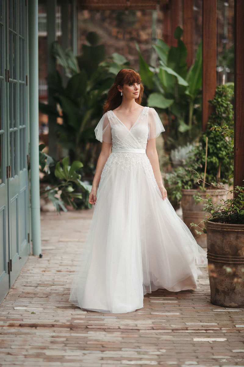 Bride wearing Dahlia gown with flowing skirt.