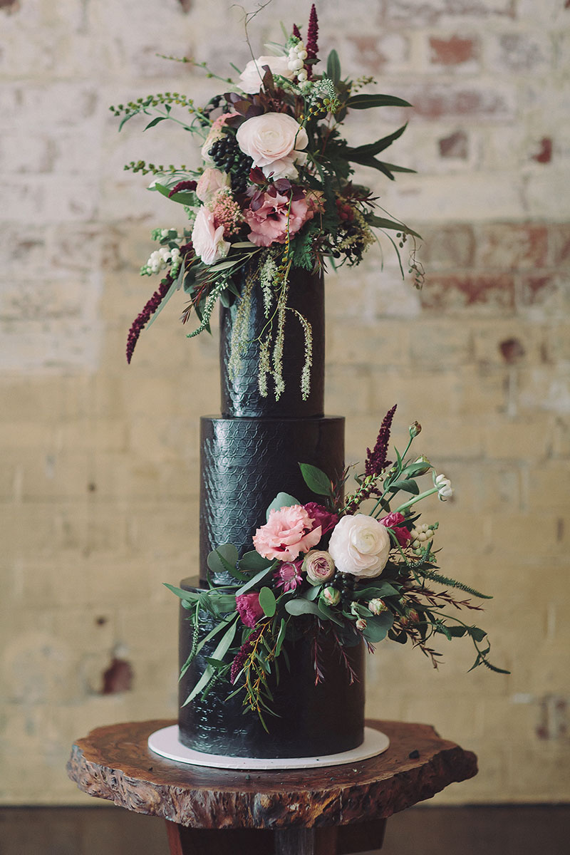 Tall Black wedding cake with florals.