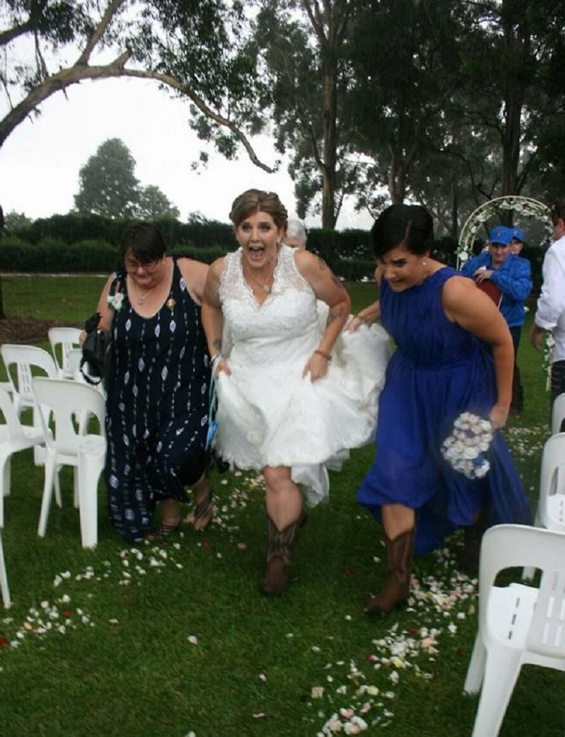 Bride running from outside ceremony to undercover.