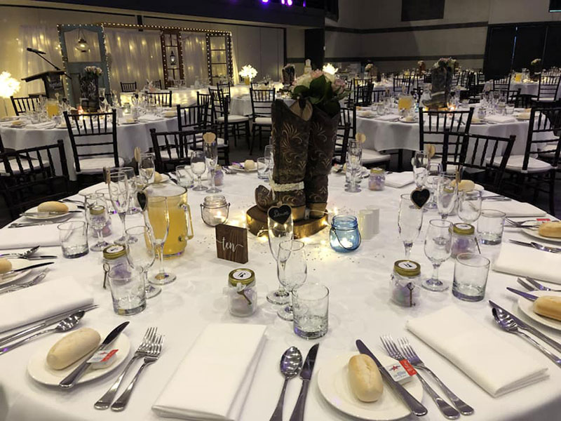 Tables at wedding reception set up with boots as the centrepieces.