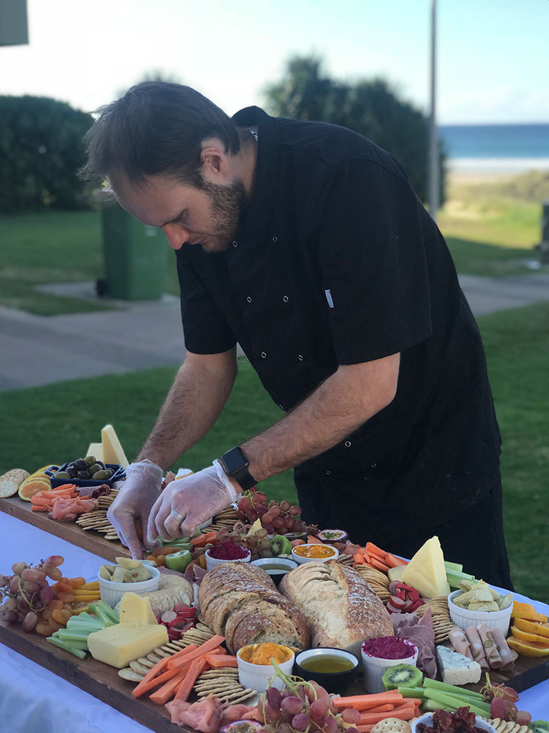 Grazing table catering being set up at the beach.