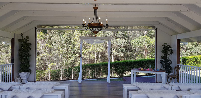 White seats and white arbour set up for a wedding ceremony at Austinvilla Estate.