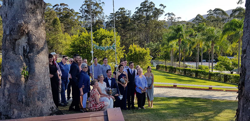 Family and friends posing for a photo with married couple.