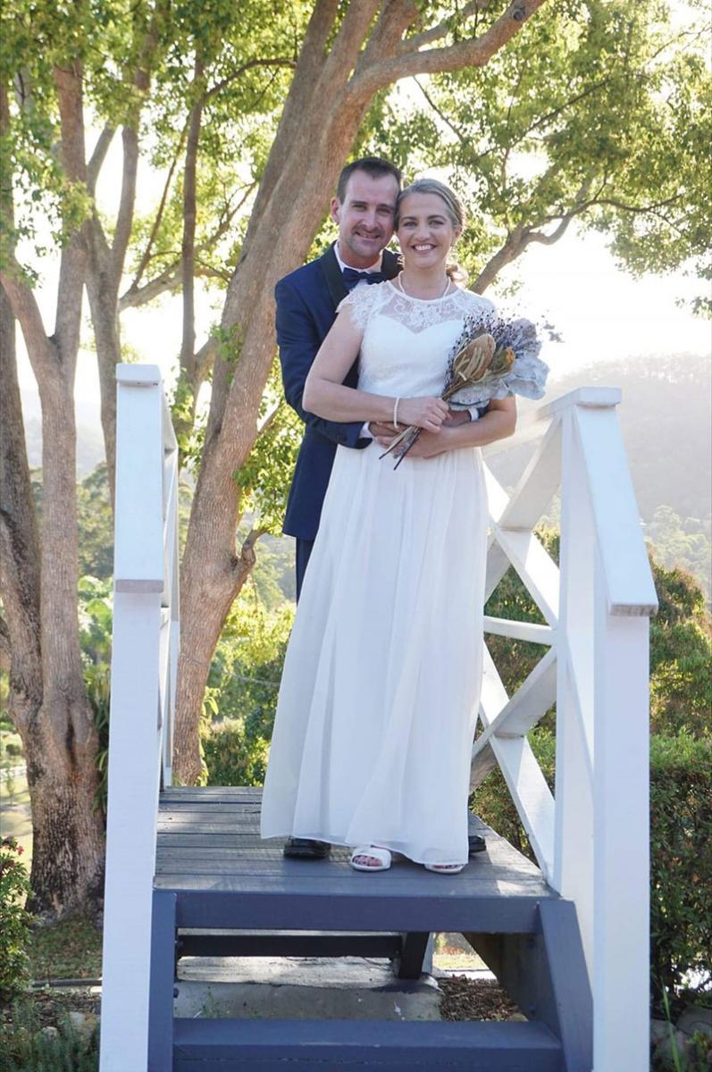 Happy married couple standing on platform.