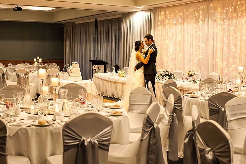 Bride and Groom standing in their wedding reception space at Lakelands Golf Club.