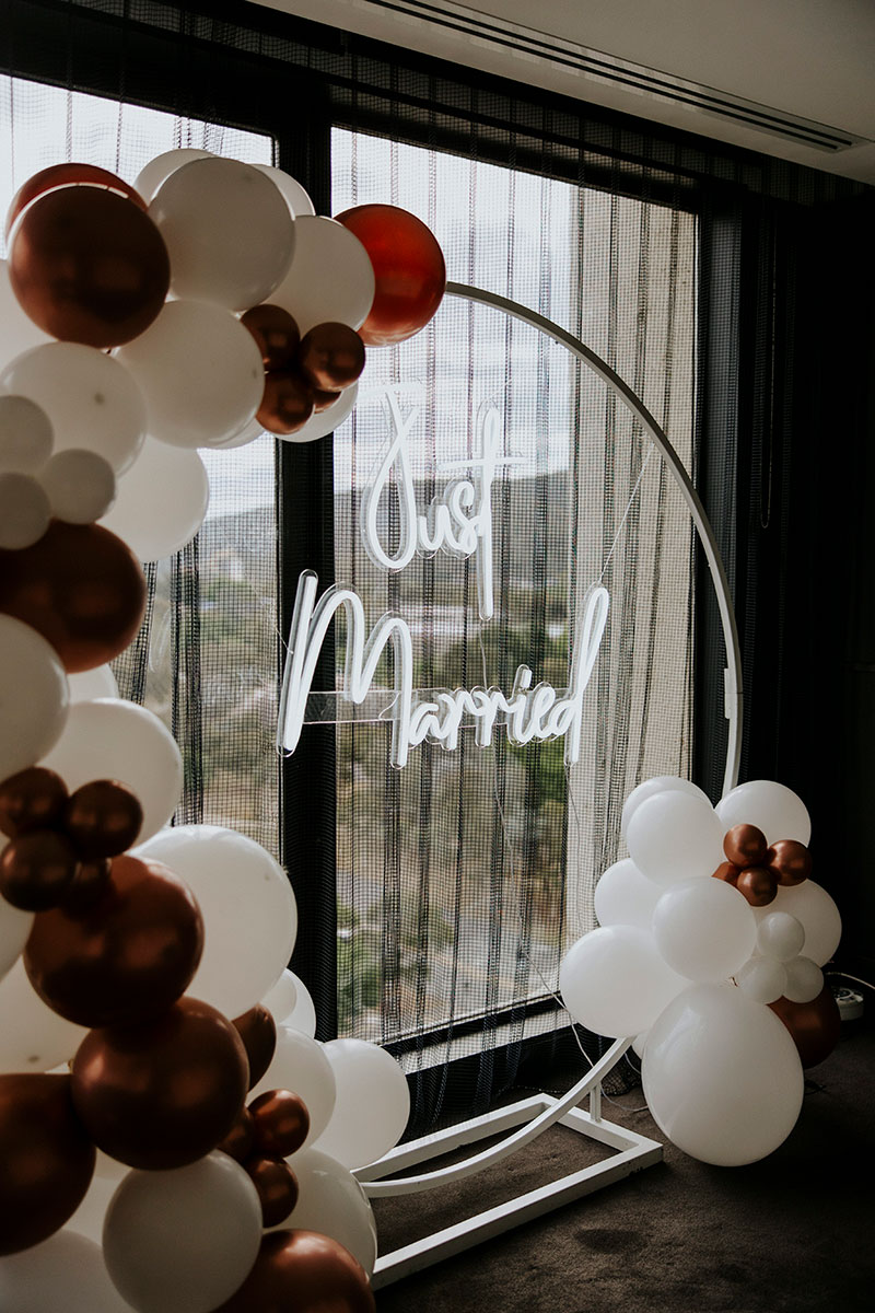 A neon sign frame & balloon garland hire package from Happy Days Canberra.