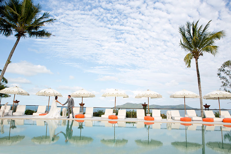 Bride and Groom in an exotic location with large pool in foreground.