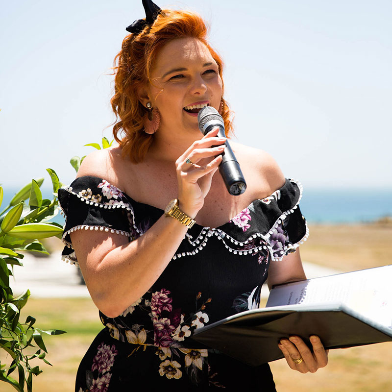 Nicole Penning Civil Celebrant speaking through microphone at an outdoor wedding.