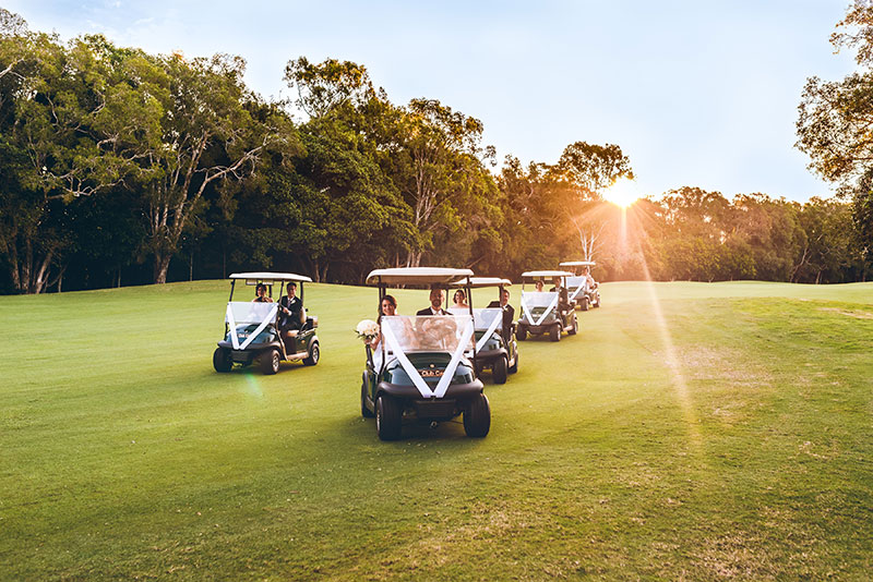 Having fun driving golf buggies on wedding day at Noosa Springs Golf & Spa Resort.