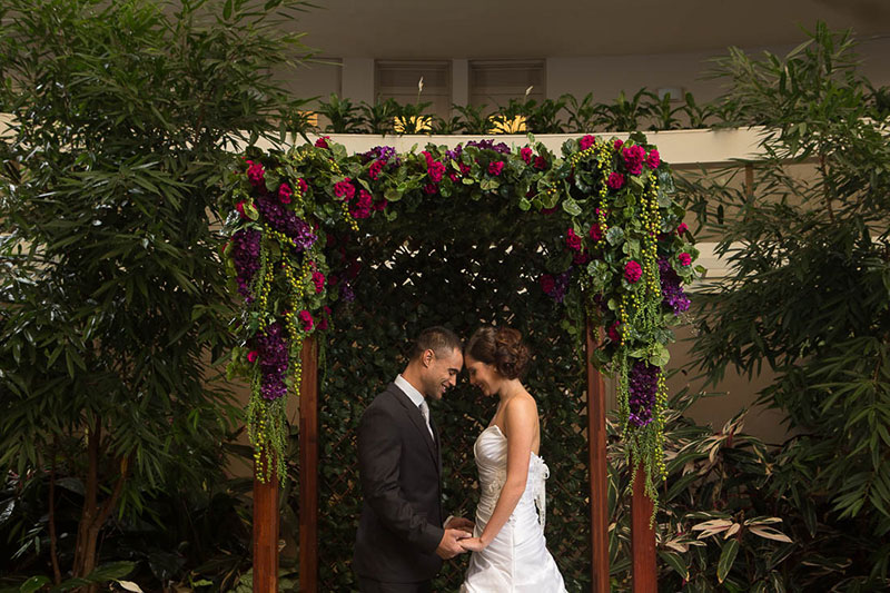 Couple getting married in front of Pavilion on Northbourne's Tropical Garden Atrium.