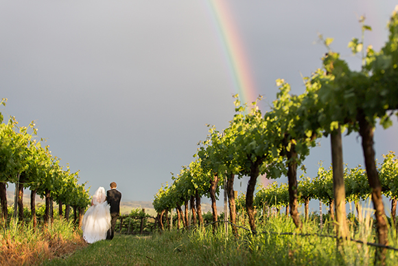 Beautiful shot of Margaret and Michael walking under a dark sky with a rainbow above.