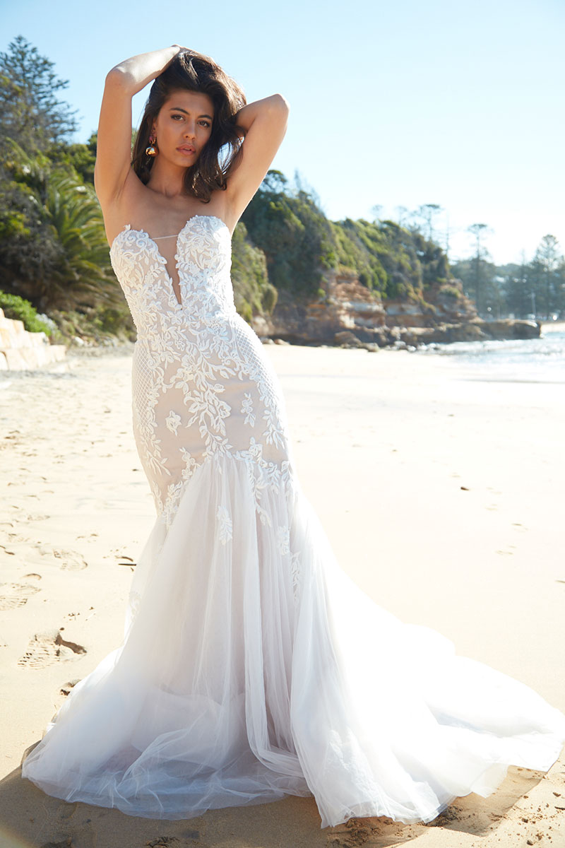 Cora from Sarah Joseph Couture worn by model in a beach setting.